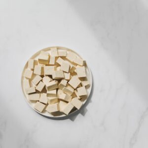 Top view of cubed tofu on a white plate, perfect for culinary projects